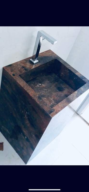 Lavatório esculpido em pedra natural escura