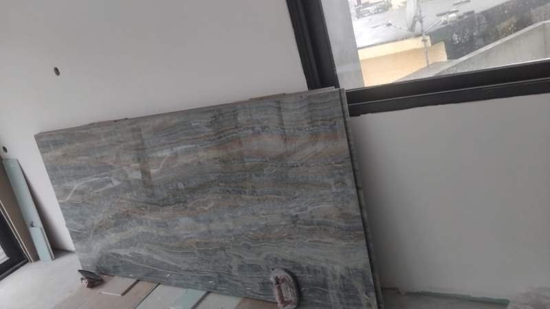 Instalação de chuveiro com revestimento em azulejo de pedra